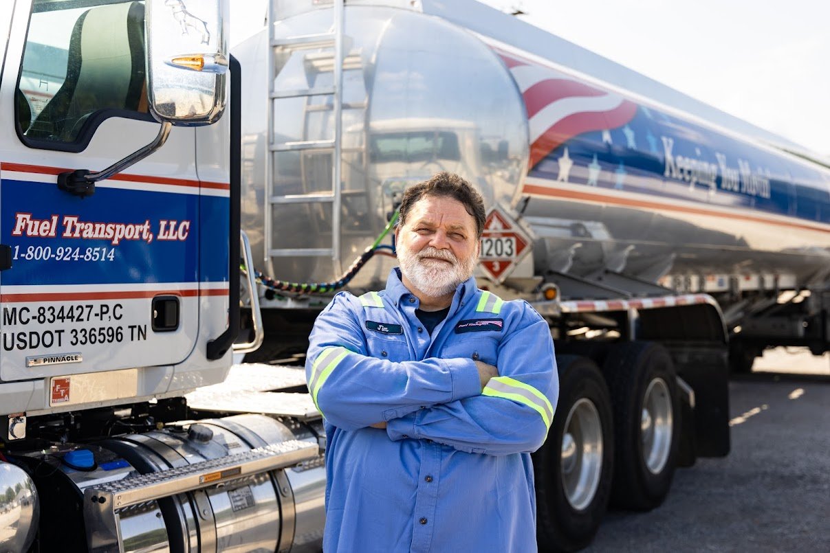 A service attendant standing in front of his truck