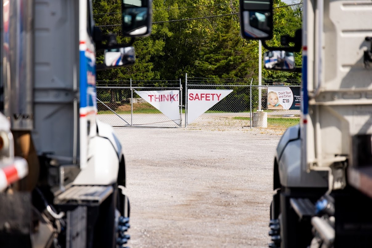 a Think! Safety sign hanging from the gate of the truck yard